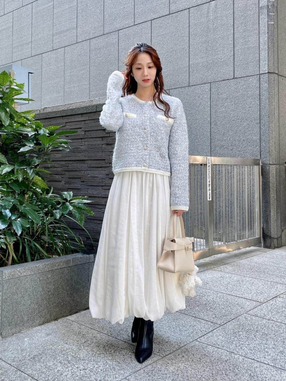 ブルー系のカーディガン/ボレロ、ホワイト系のスカート、ホワイト系のトートバッグを着用したレディースの秋コーディネートの2枚目の写真