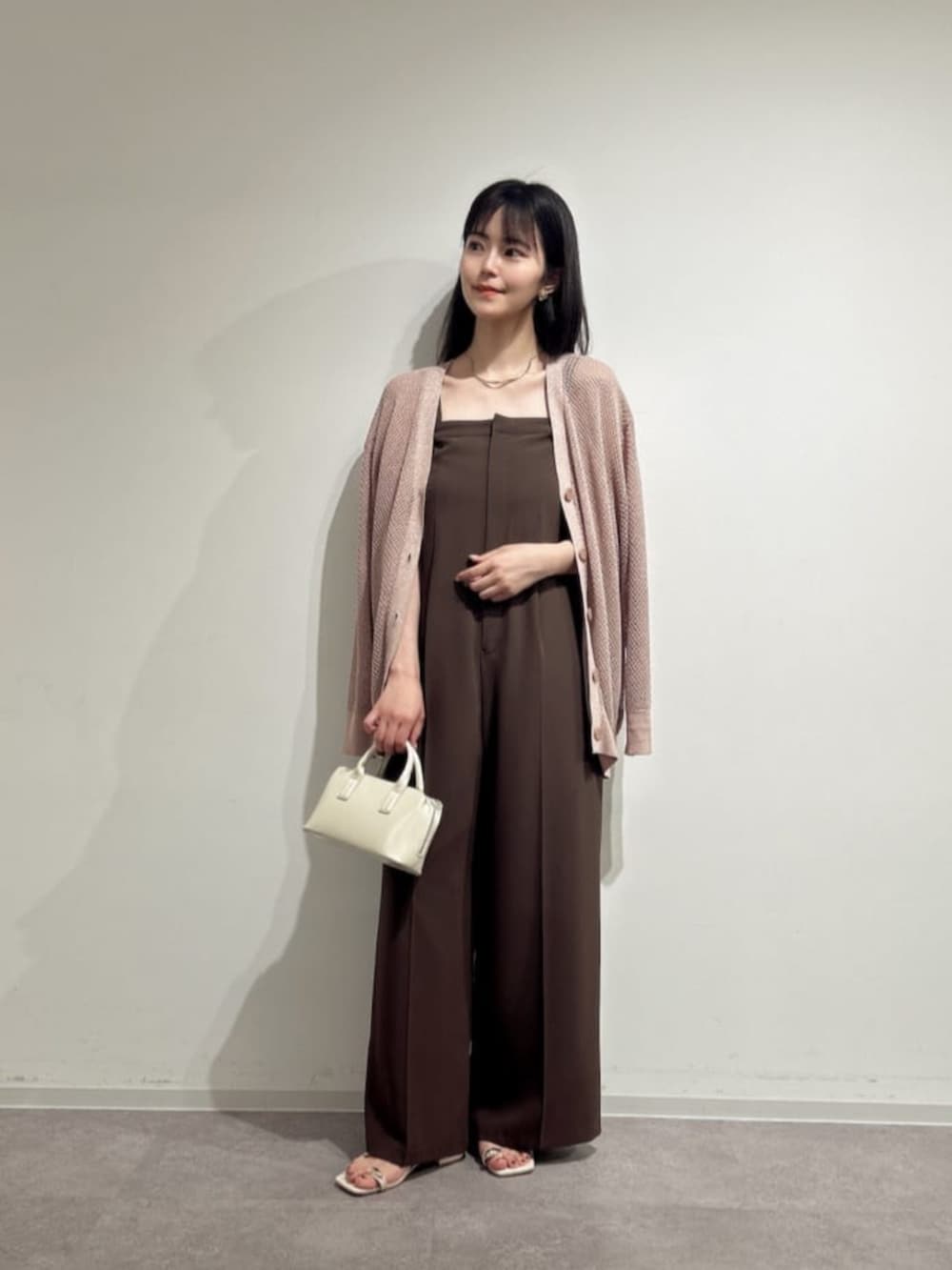 ホワイト系のパンプス、ホワイト系のトートバッグ、ピンク系のニット/セーターを着用したレディースの夏コーディネートの3枚目の写真