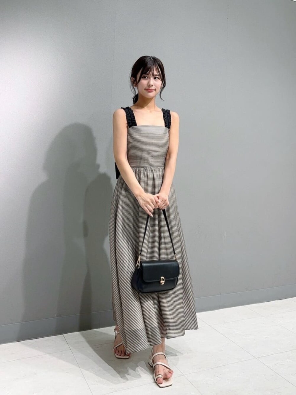 ホワイト系のパンプス、ホワイト系のカーディガン/ボレロ、ブラウン系のワンピースを着用したレディースの春コーディネートの2枚目の写真