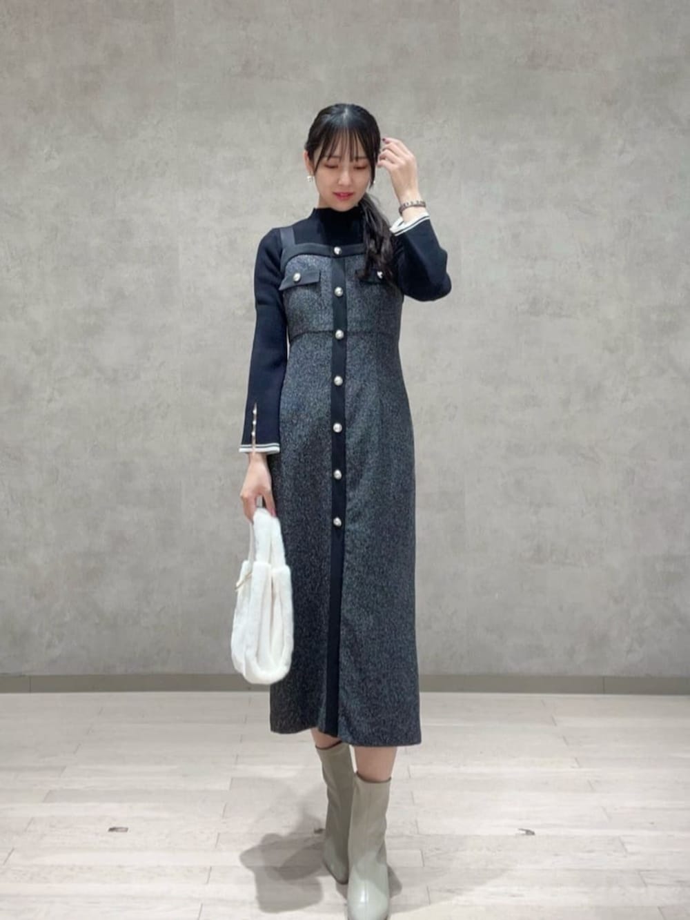 ブラック系のニット/セーター、ブラック系のワンピース、ホワイト系のトートバッグを着用したレディースの秋コーディネートの2枚目の写真