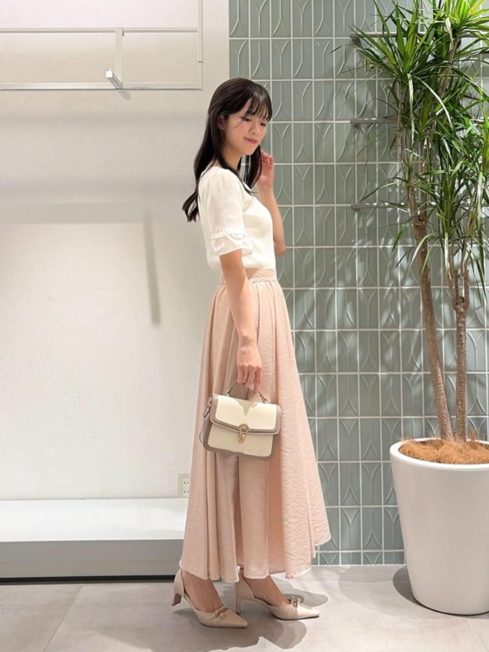 ベージュ系のパンプス、グレー系のショルダーバッグ、ホワイト系のニット/セーターを着用したレディースの夏コーディネートの2枚目の写真