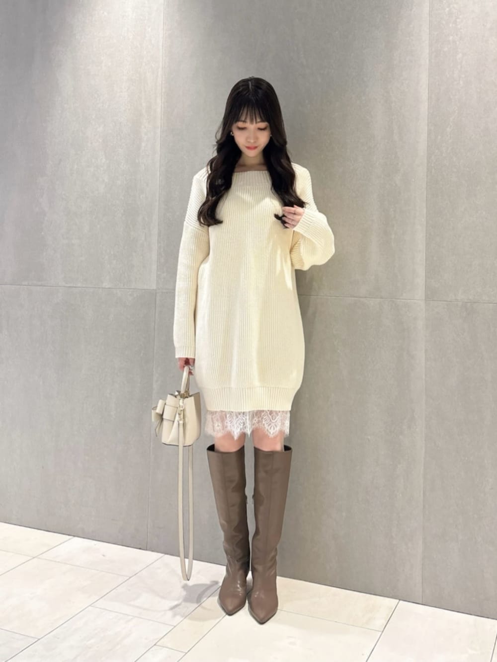 ブラウン系のブーツ、ホワイト系のショルダーバッグ、ホワイト系のワンピースを着用したレディースの春コーディネートの2枚目の写真