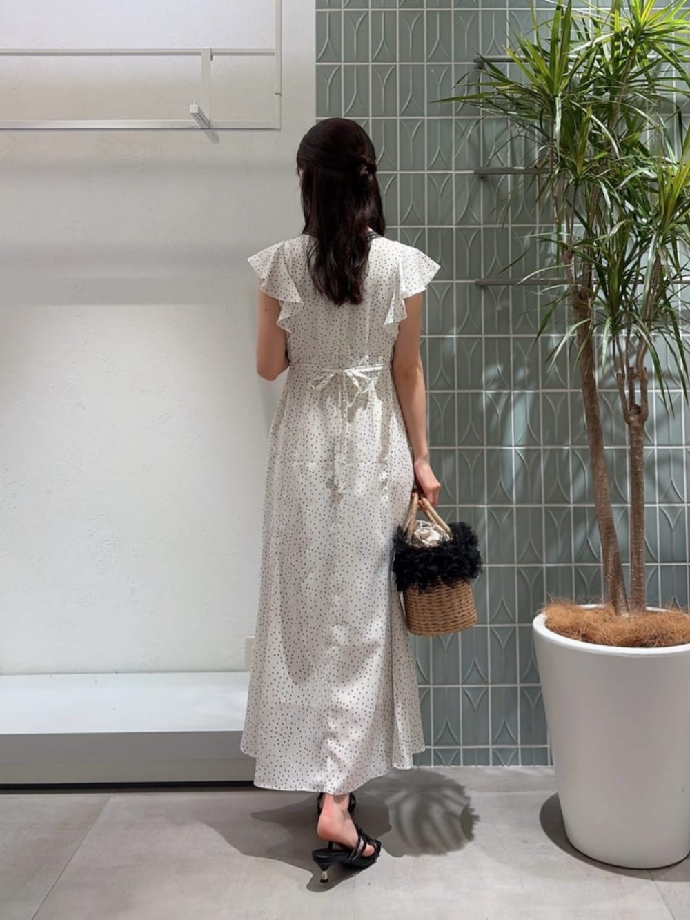 ブラック系のパンプス、ブラック系のショルダーバッグ、ホワイト系のワンピースを着用したレディースの夏コーディネートの3枚目の写真