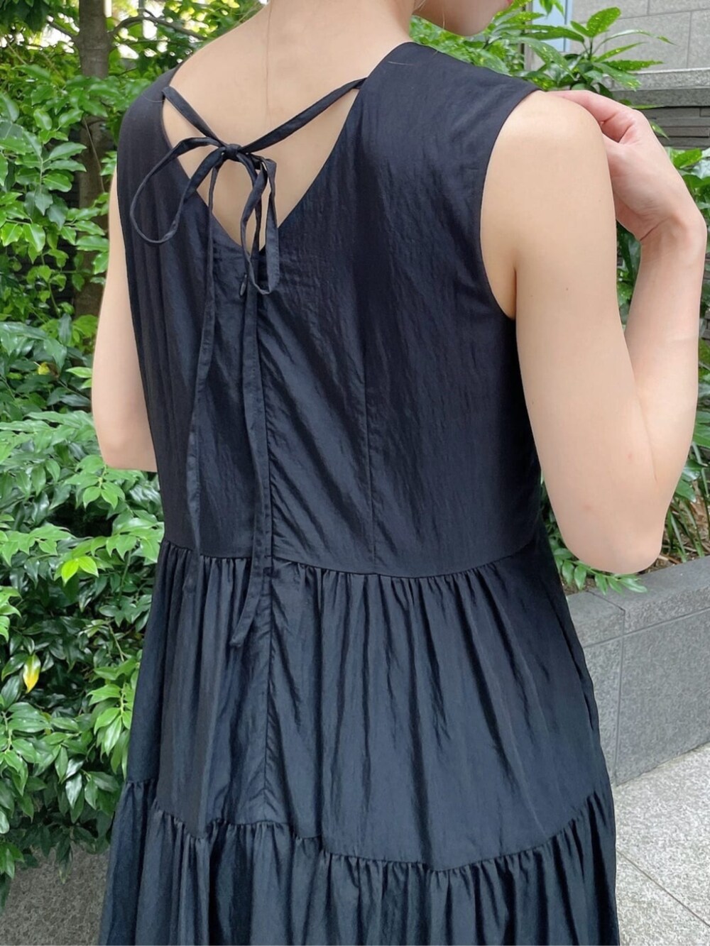 ブラック系のパンプス、ホワイト系のニット/セーター、ブラック系のワンピースを着用したレディースの夏コーディネートの3枚目の写真