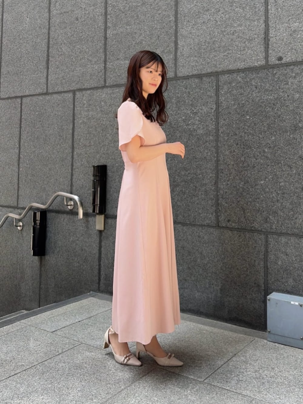 ホワイト系のショルダーバッグ、ベージュ系のパンプス、ピンク系のワンピースを着用したレディースの春コーディネートの2枚目の写真
