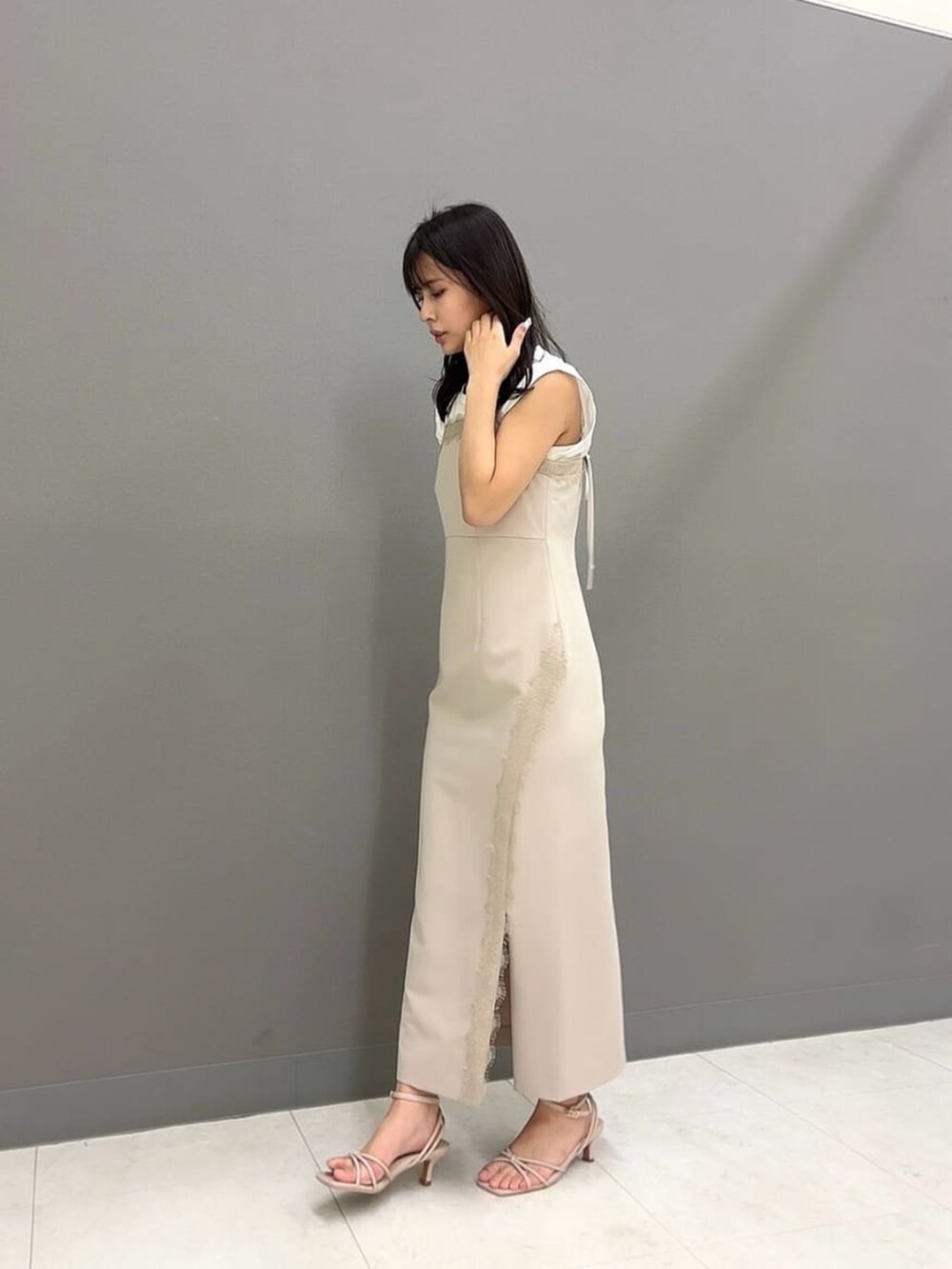 ホワイト系のショルダーバッグ、ホワイト系のTシャツ/カットソー、ベージュ系のワンピースを着用したレディースの夏コーディネートの2枚目の写真