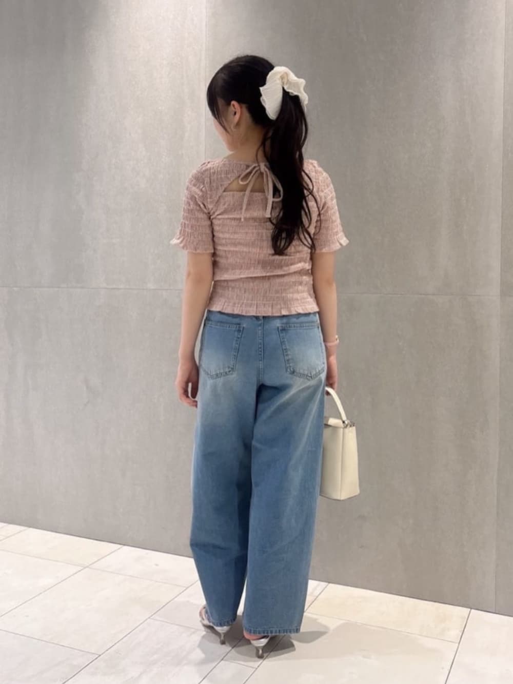 ホワイト系のショルダーバッグ、シルバー系のパンプス、ピンク系のTシャツ/カットソーを着用したレディースの春コーディネートの3枚目の写真