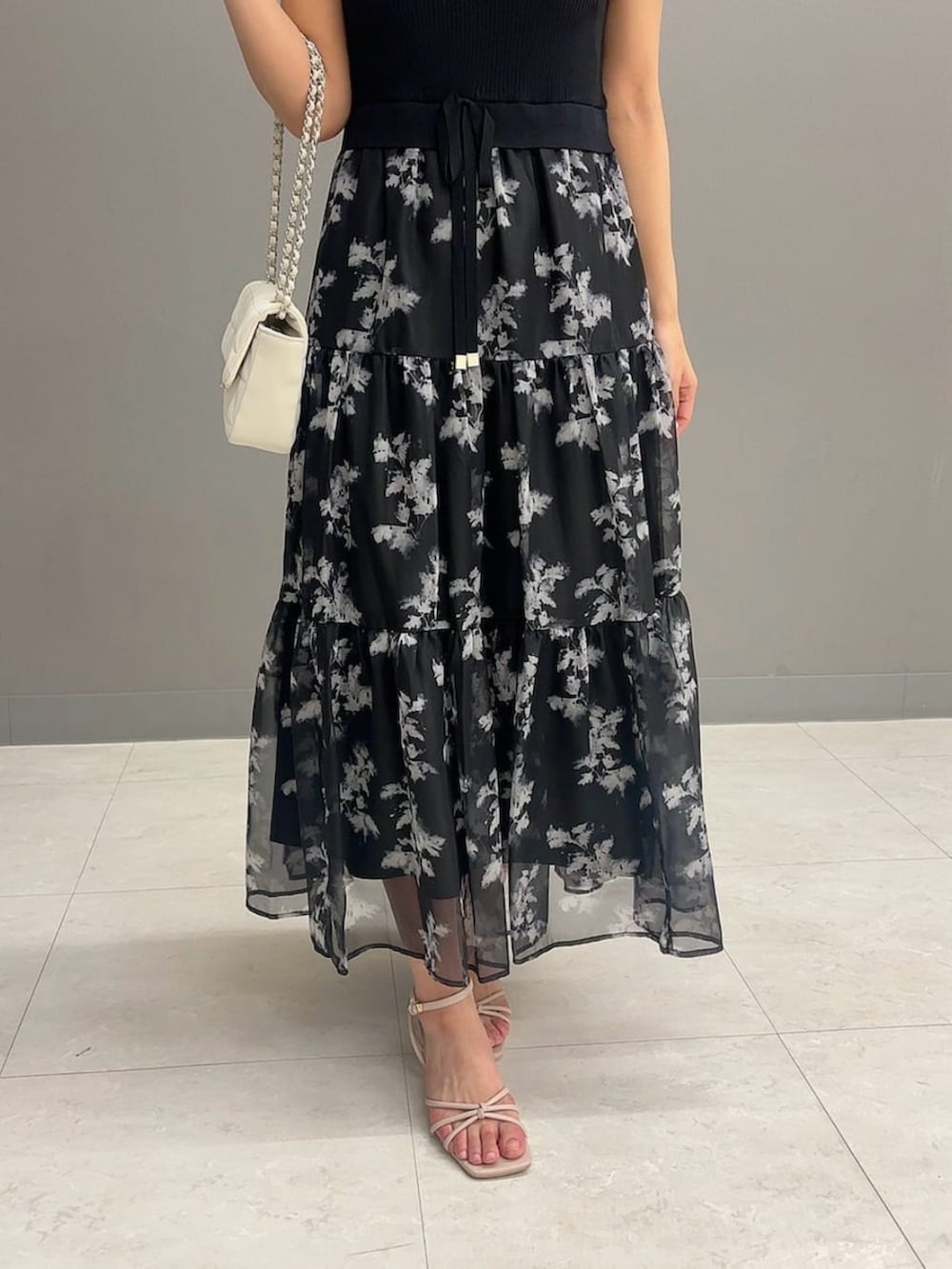 ホワイト系のショルダーバッグ、ブラック系のワンピースを着用したレディースの夏コーディネートの3枚目の写真