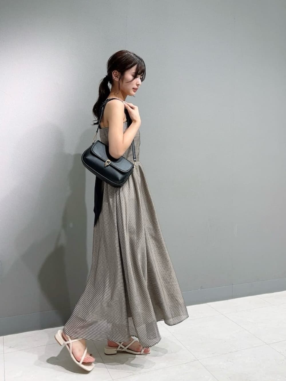 ホワイト系のパンプス、ホワイト系のカーディガン/ボレロ、ブラウン系のワンピースを着用したレディースの春コーディネートの3枚目の写真