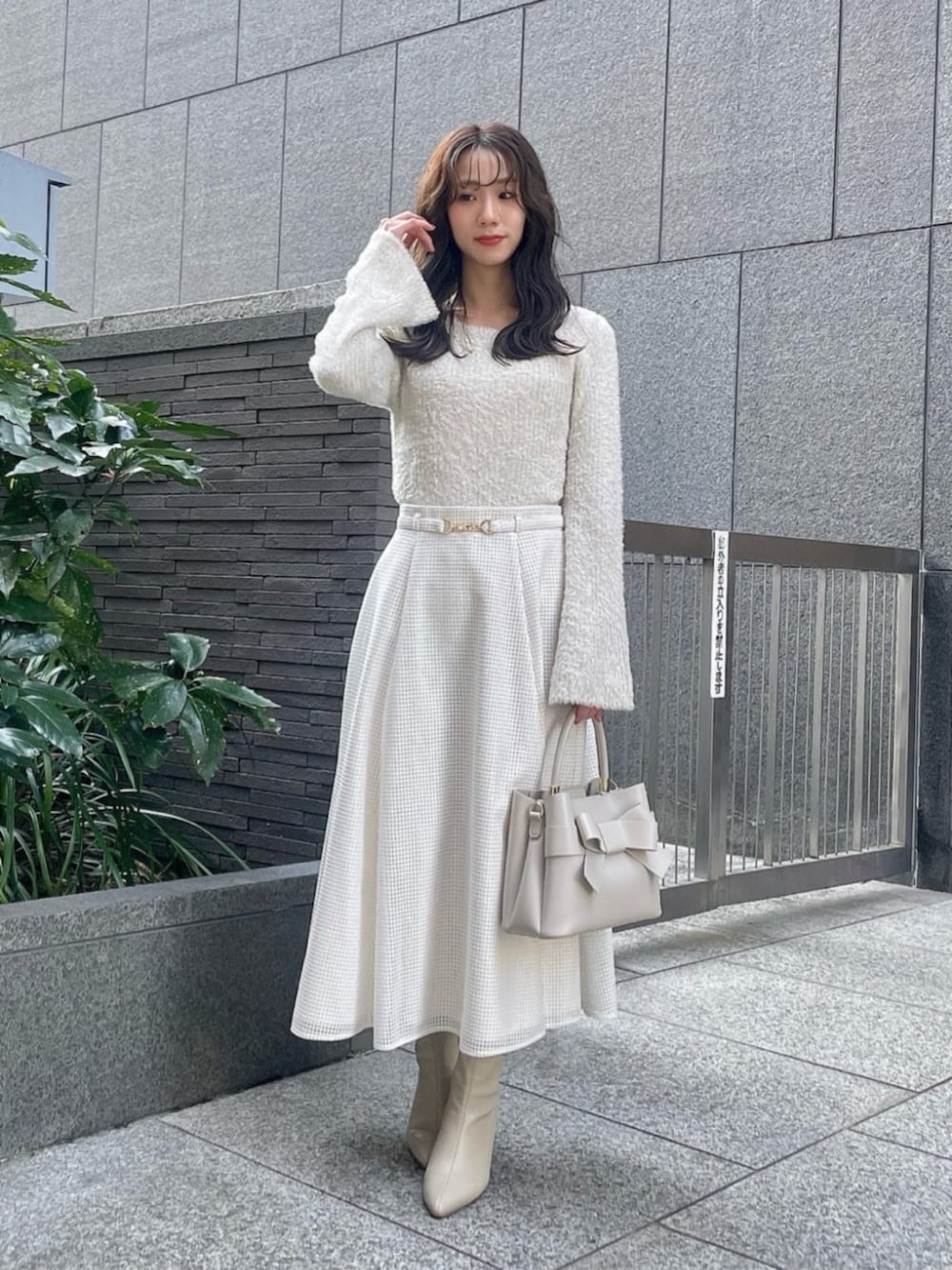 ホワイト系のスカート、ベージュ系のテーラードジャケット、ベージュ系のニット/セーターを着用したレディースの冬コーディネートの3枚目の写真