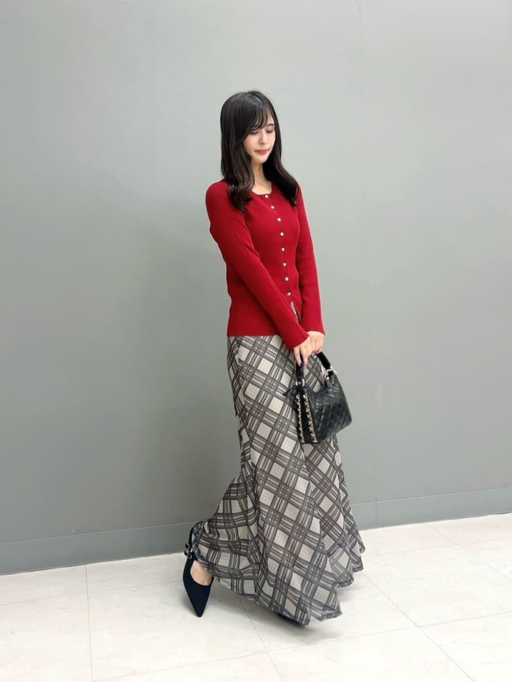 ブラック系のパンプス、レッド系のカーディガン/ボレロ、ベージュ系のスカートを着用したレディースの秋コーディネートの2枚目の写真