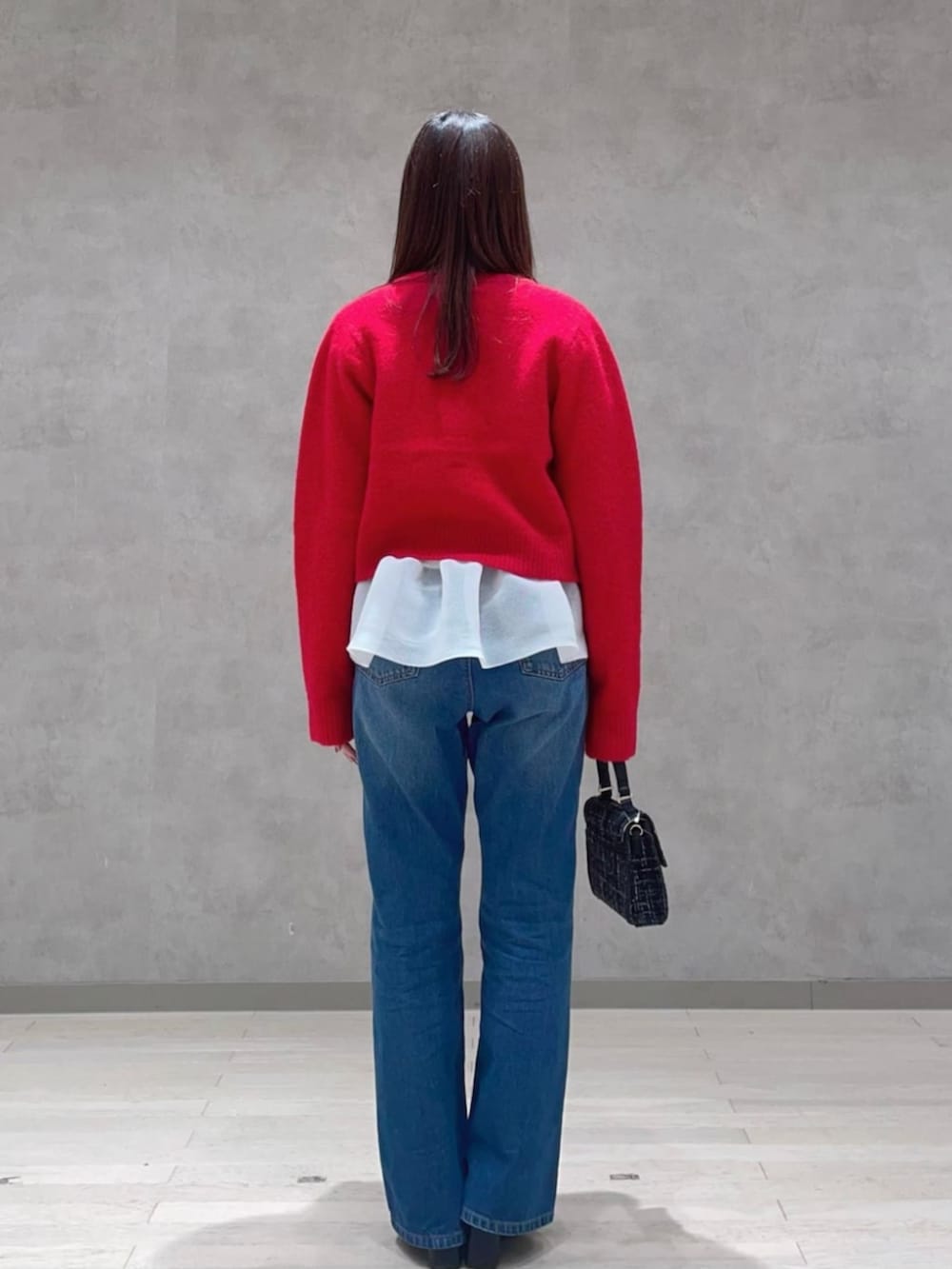 ブラック系のショルダーバッグ、ブルー系のその他パンツ、レッド系のカーディガン/ボレロを着用したレディースの冬コーディネートの2枚目の写真