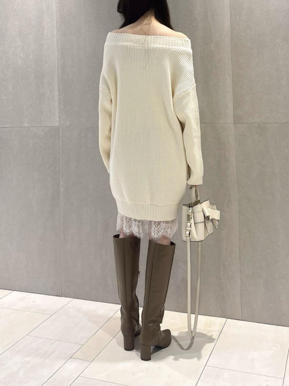 ブラウン系のブーツ、ホワイト系のショルダーバッグ、ホワイト系のワンピースを着用したレディースの春コーディネートの3枚目の写真