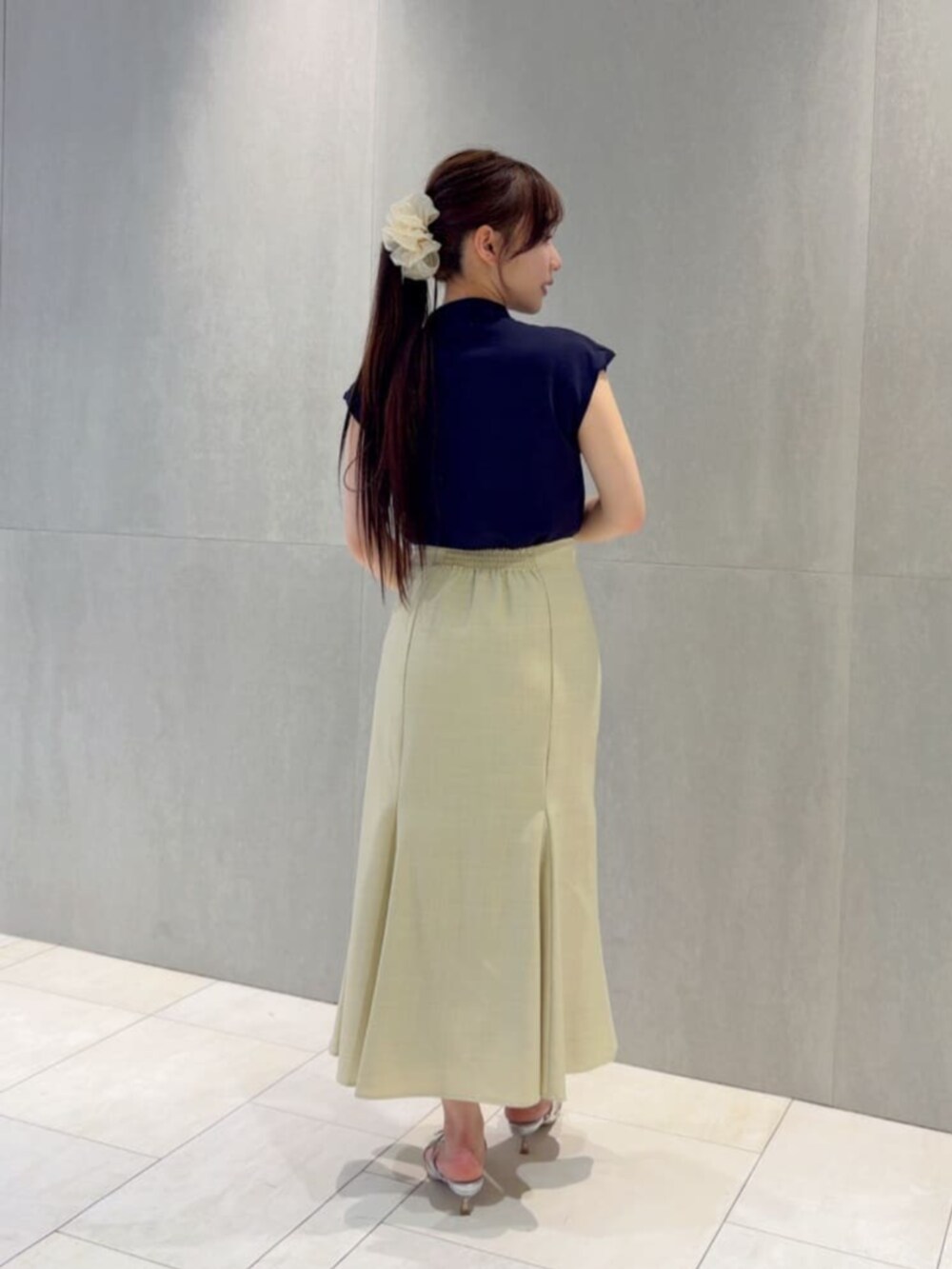 シルバー系のパンプス、ブルー系のニット/セーター、イエロー系のスカートを着用したレディースの夏コーディネートの3枚目の写真