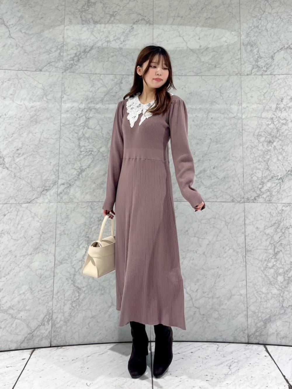 ホワイト系のトートバッグ、ブラウン系のワンピースを着用したレディースの冬コーディネートの2枚目の写真