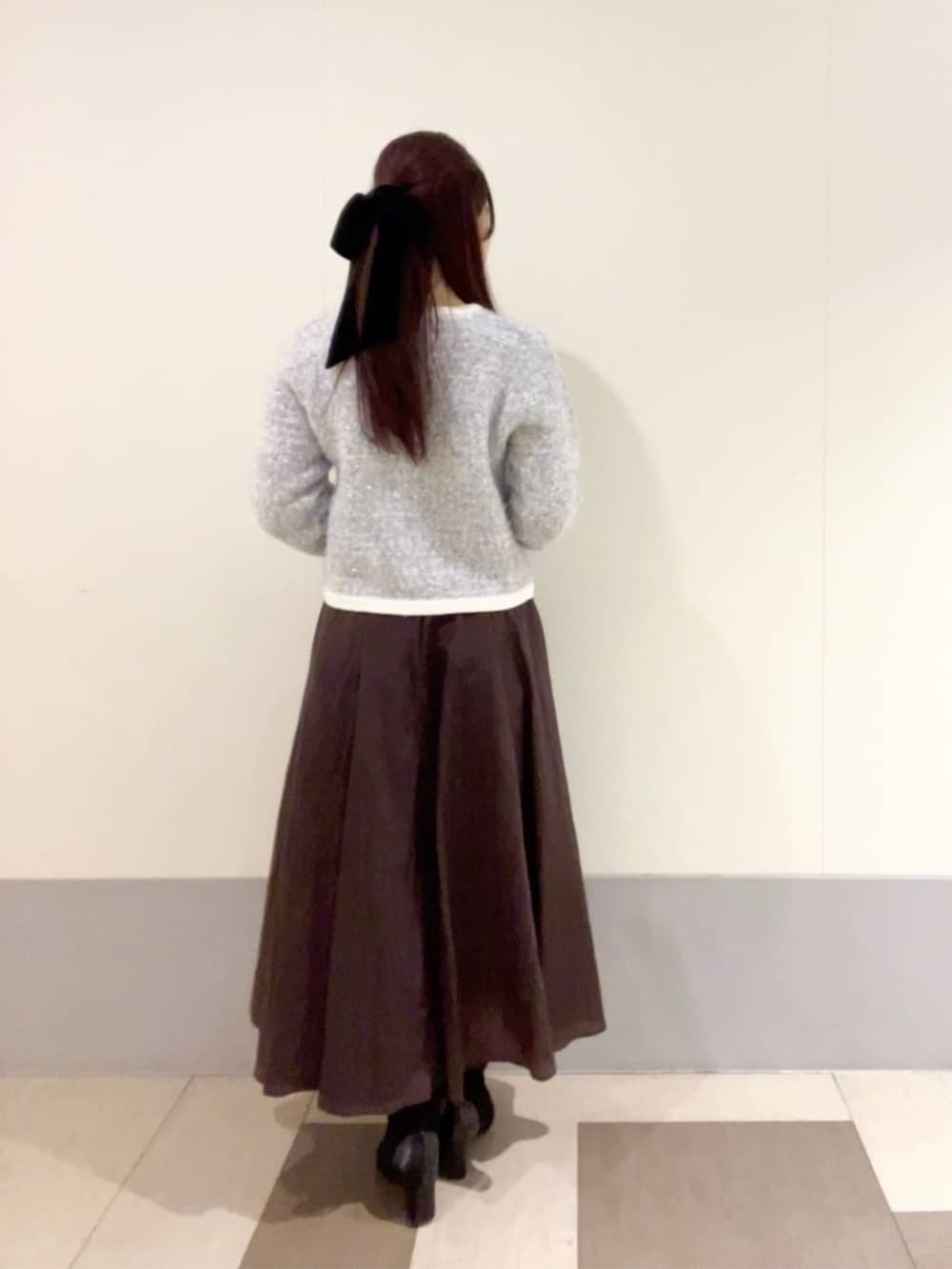 ブルー系のカーディガン/ボレロ、ブラウン系のスカートを着用したレディースの冬コーディネートの3枚目の写真