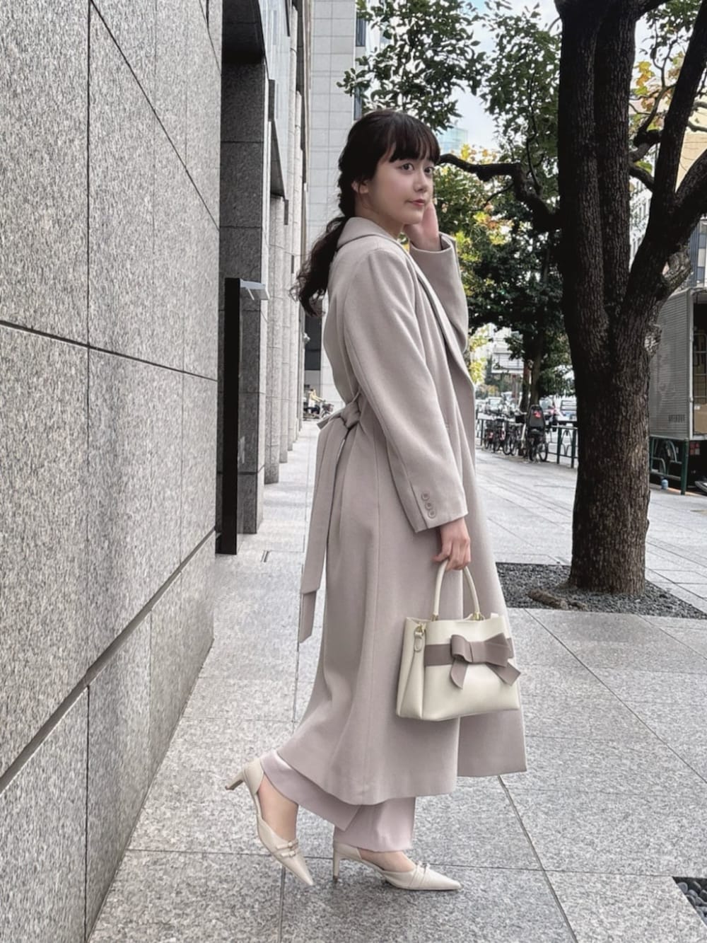 ベージュ系のステンカラーコート、ベージュ系のセットアップ、ベージュ系のその他パンツを着用したレディースの冬コーディネートの2枚目の写真