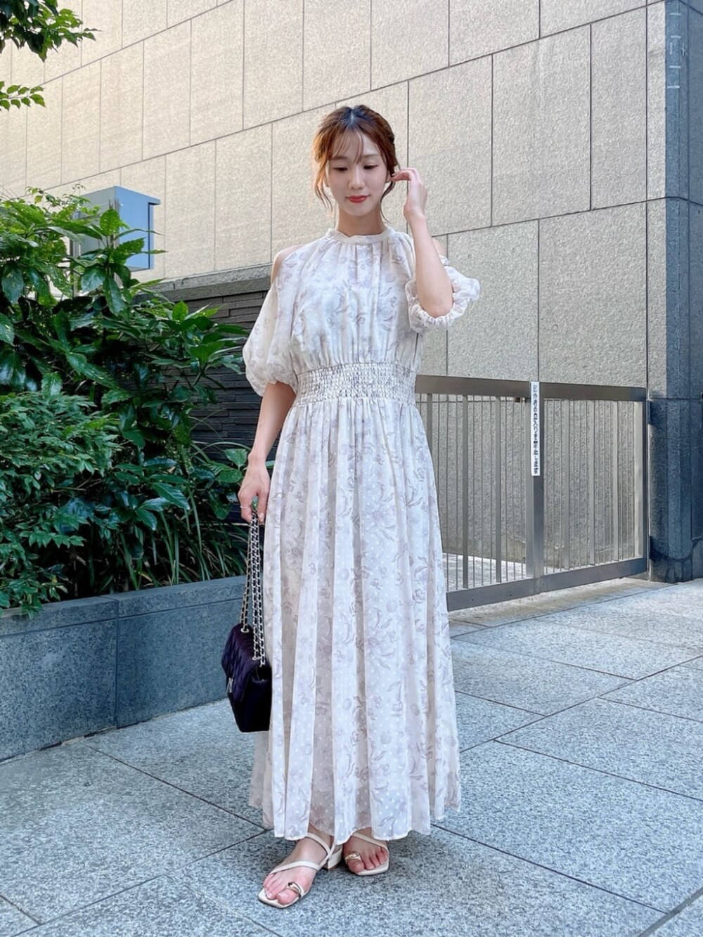 ブラウン系のショルダーバッグ、ホワイト系のパンプス、ホワイト系のワンピースを着用したレディースの夏コーディネートの2枚目の写真