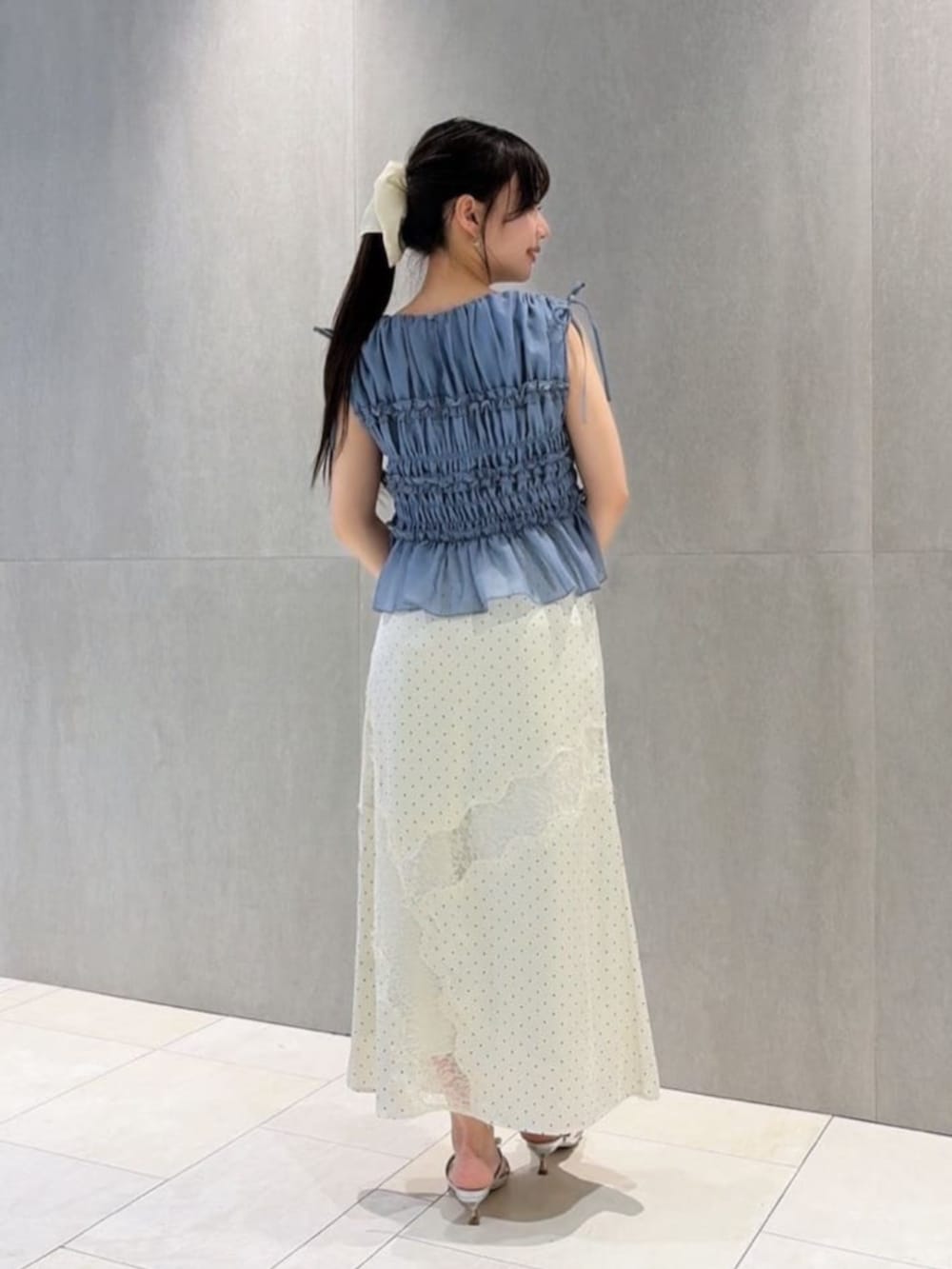 シルバー系のパンプス、ホワイト系のスカート、ブルー系のシャツ/ブラウスを着用したレディースの夏コーディネートの3枚目の写真