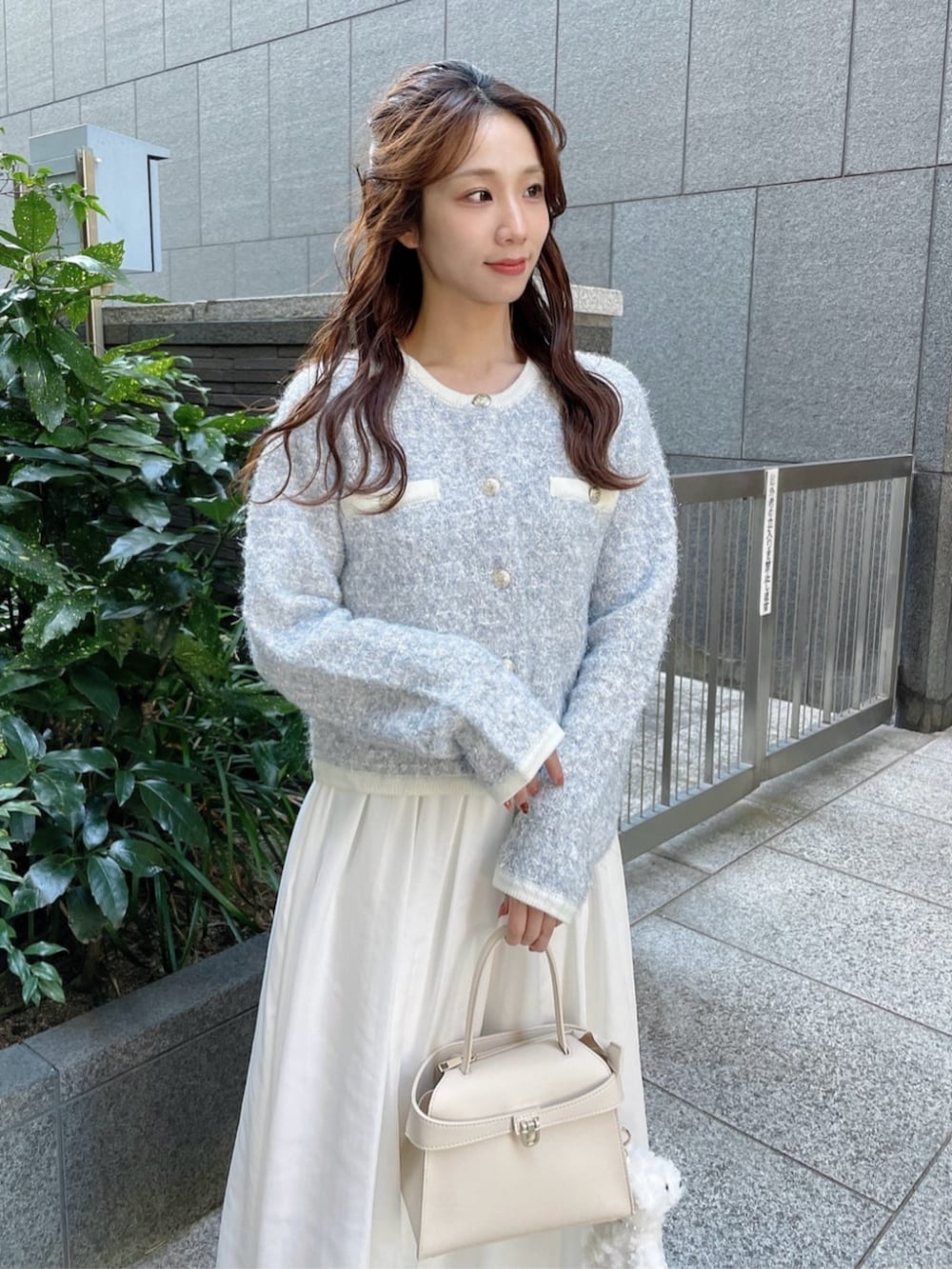 ブルー系のカーディガン/ボレロ、ホワイト系のスカート、ホワイト系のトートバッグを着用したレディースの秋コーディネートの3枚目の写真
