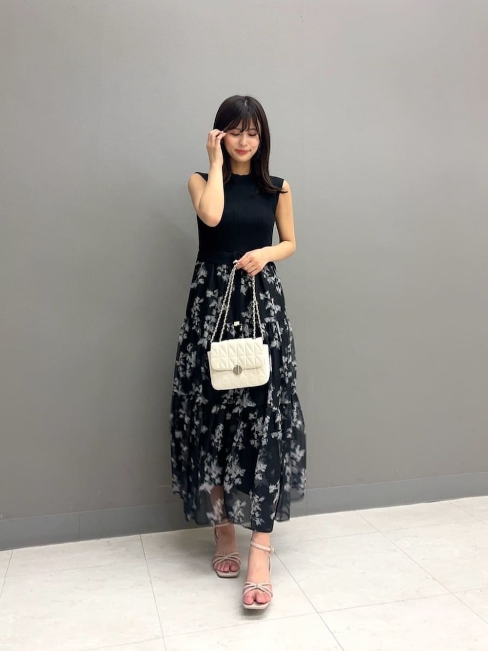 ホワイト系のショルダーバッグ、ブラック系のワンピースを着用したレディースの夏コーディネートの2枚目の写真