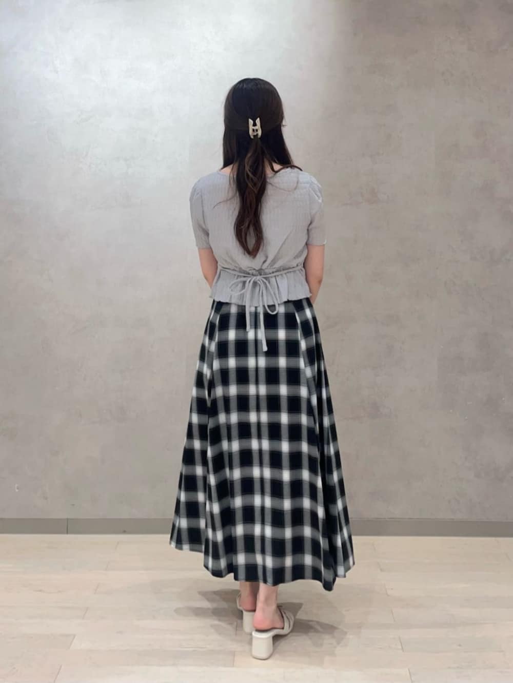 ブラック系のショルダーバッグ、グレー系のTシャツ/カットソー、ブラック系のスカートを着用したレディースの夏コーディネートの4枚目の写真