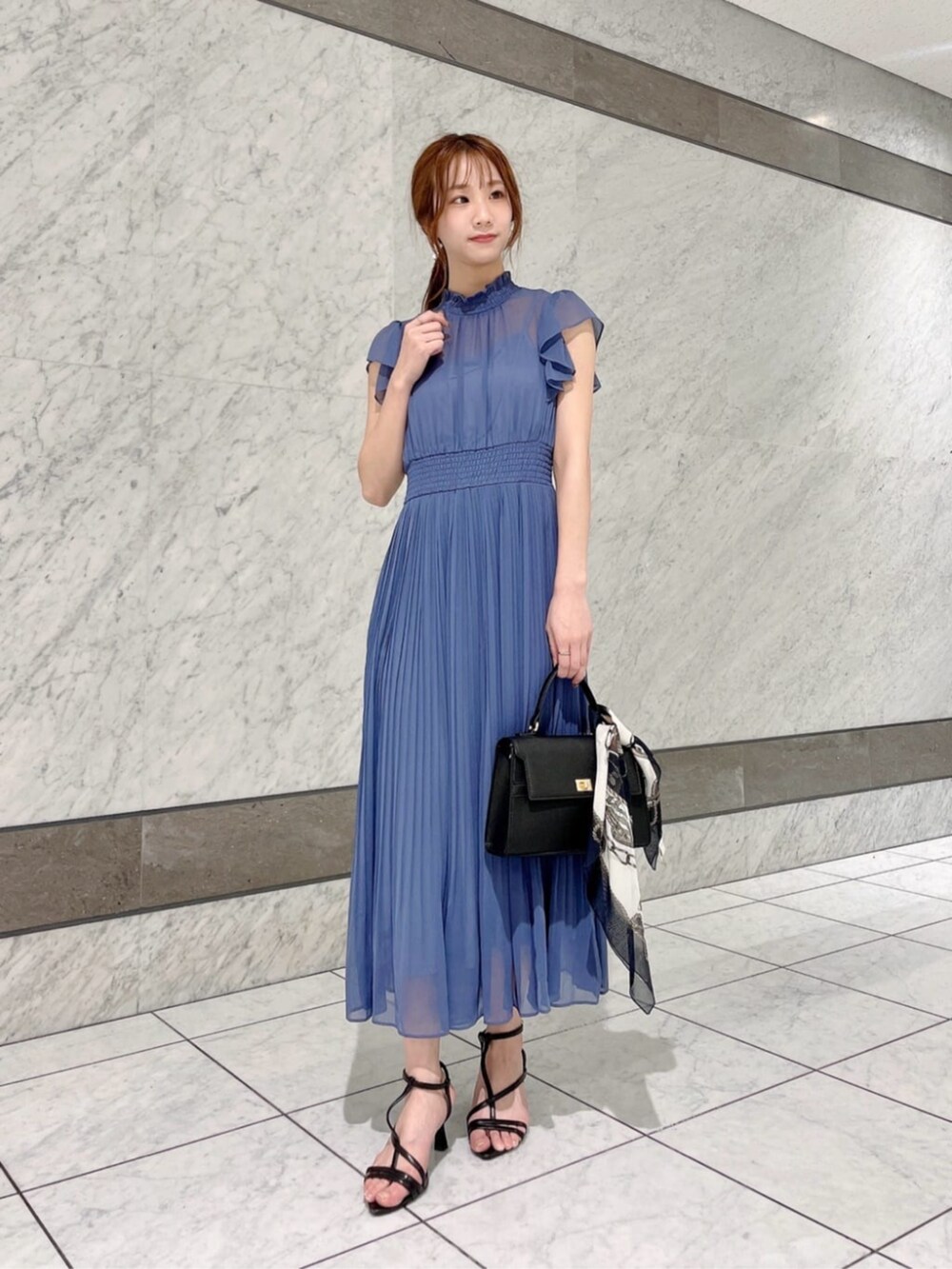 ブラック系のパンプス、ブルー系のワンピース、ブラック系のショルダーバッグを着用したレディースの夏コーディネートの2枚目の写真