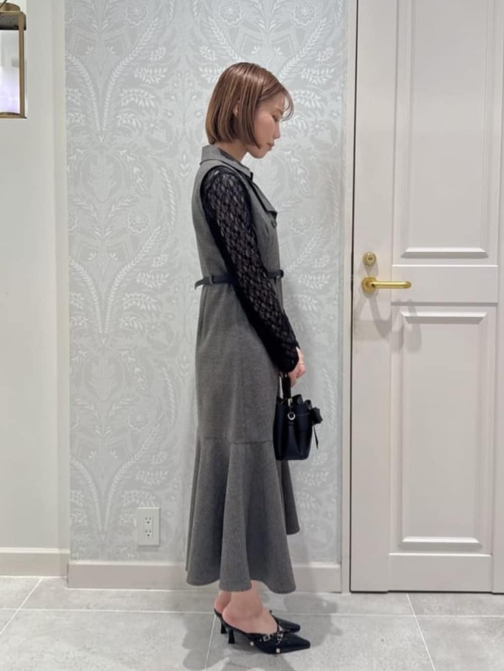 ブラック系のショルダーバッグ、ブラウン系のワンピース、ブラック系のTシャツ/カットソーを着用したレディースの秋コーディネートの2枚目の写真
