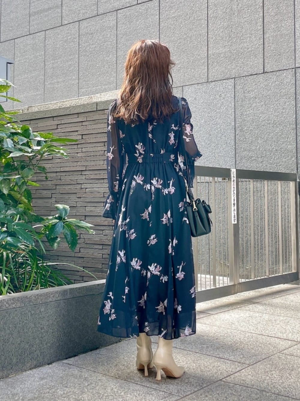 ブラック系のワンピース、ブラック系のショルダーバッグを着用したレディースの冬コーディネートの3枚目の写真