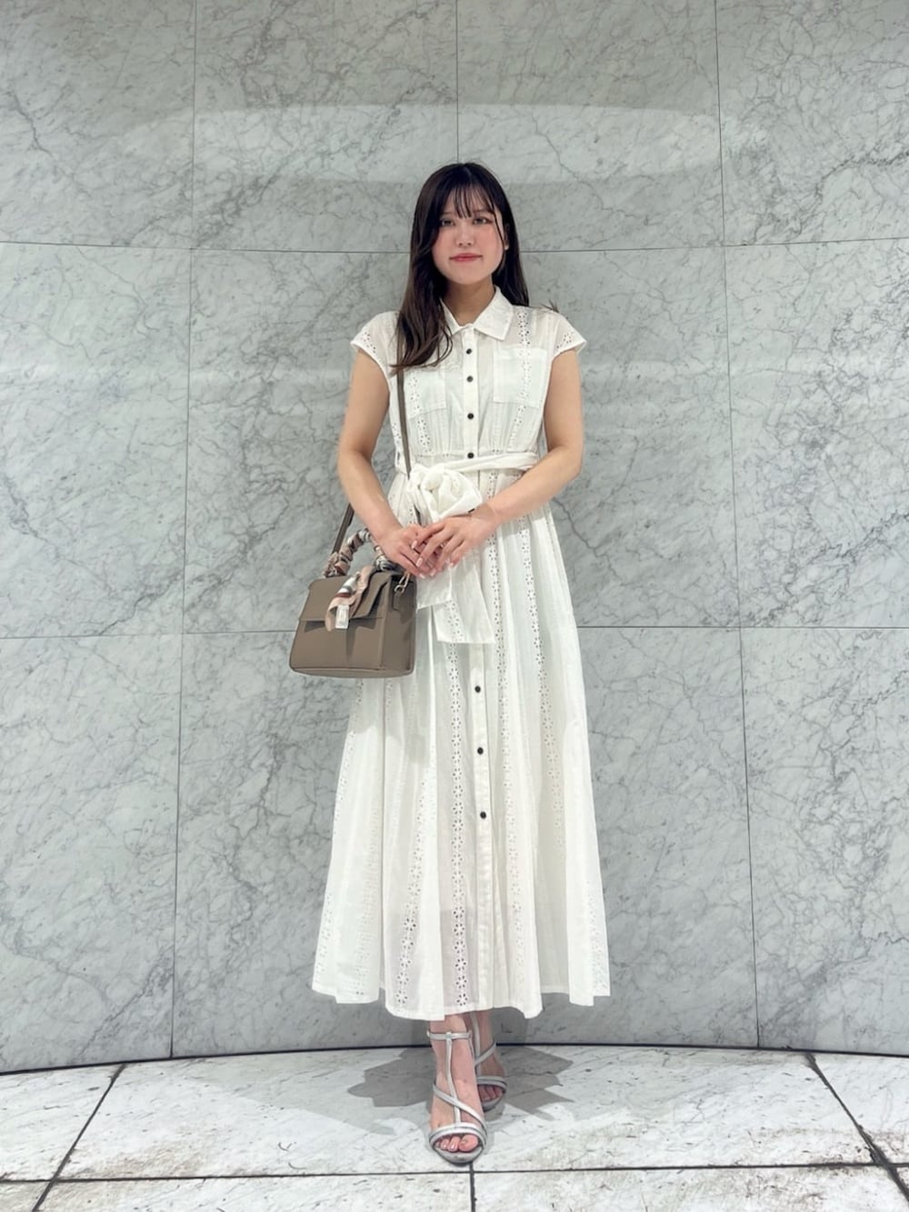 シルバー系のパンプス、ブラウン系のショルダーバッグ、ホワイト系のワンピースを着用したレディースの夏コーディネートの2枚目の写真