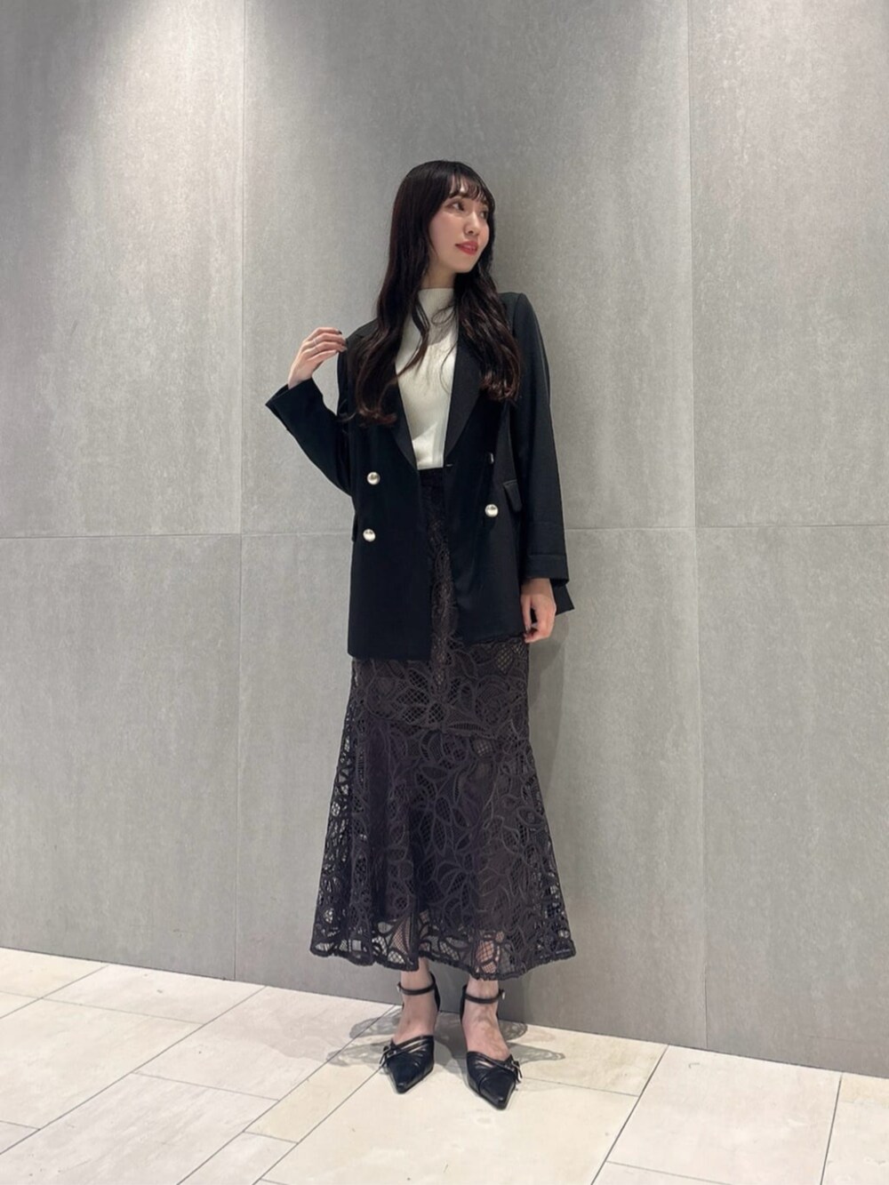 ブラック系のパンプス、ブラック系のテーラードジャケット、ホワイト系のニット/セーターを着用したレディースの秋コーディネートの3枚目の写真