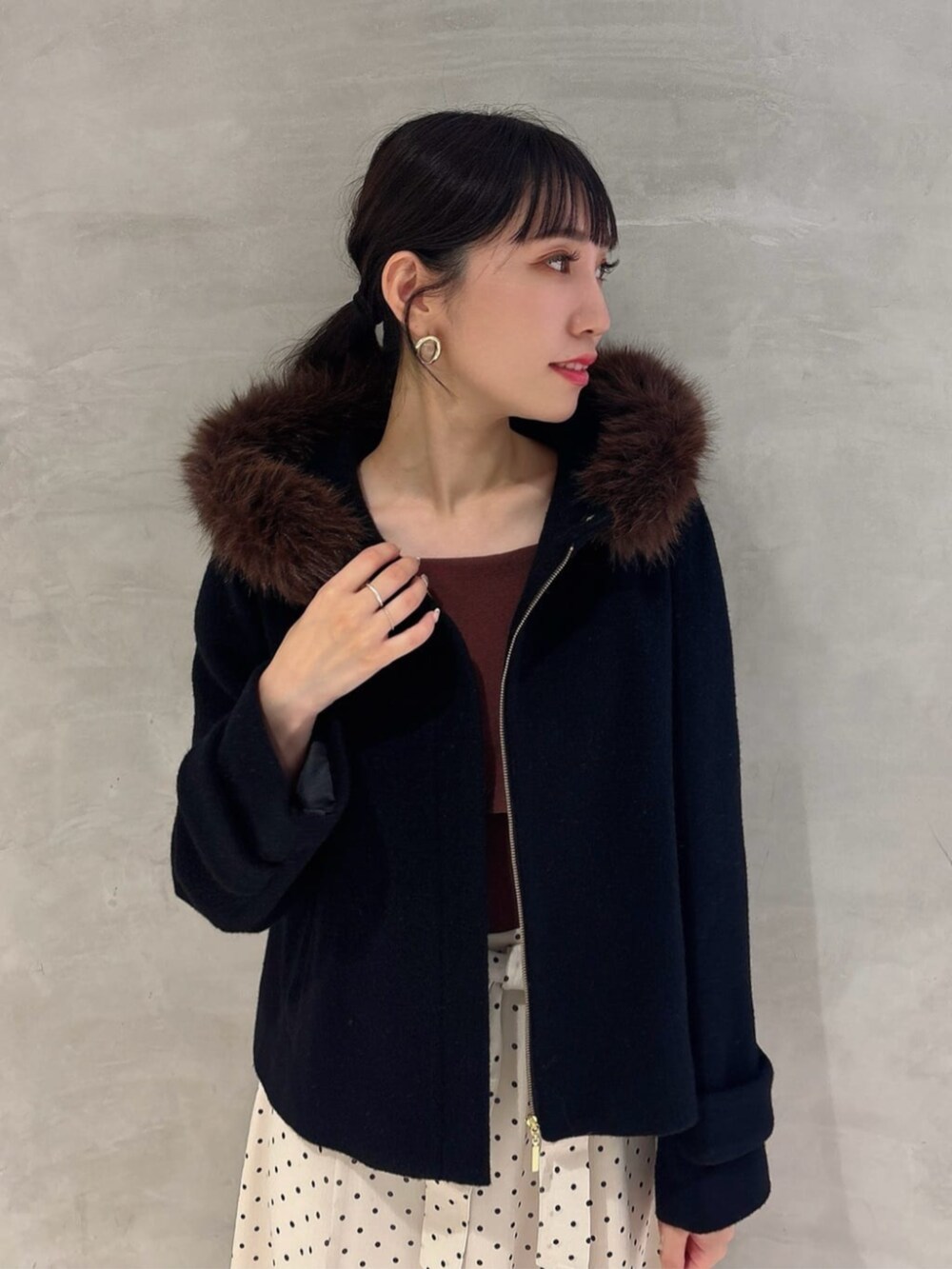 ホワイト系のワンピース、ブラック系のパンプス、ブラック系のブルゾンを着用したレディースの秋コーディネートの3枚目の写真