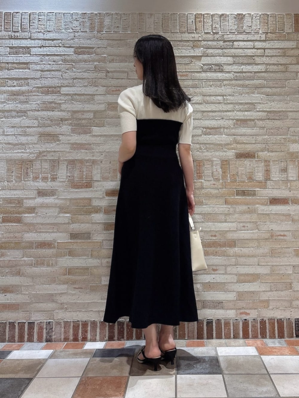 ブラック系のワンピースを着用したレディースの春コーディネートの3枚目の写真