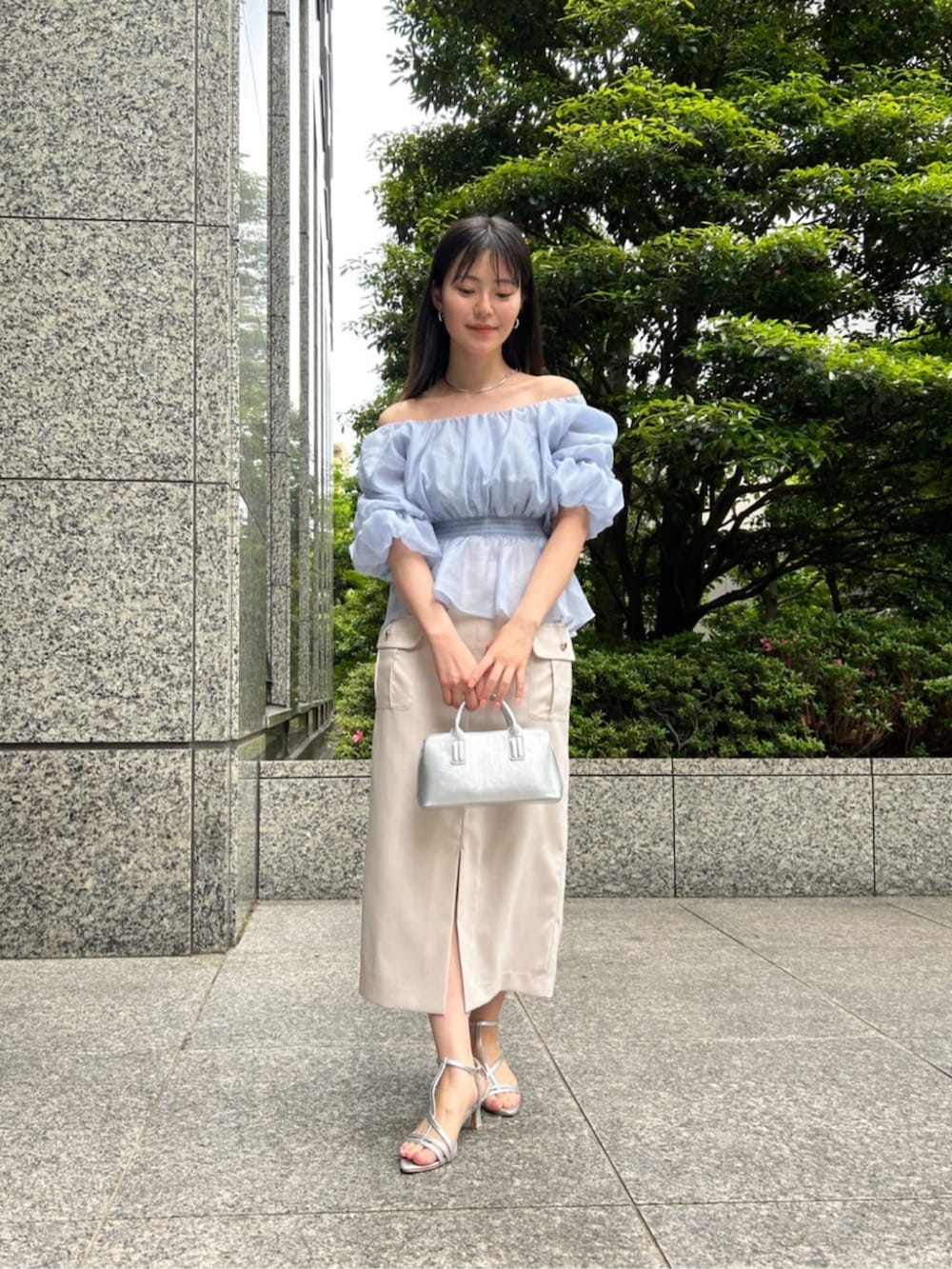 シルバー系のパンプス、ブルー系のシャツ/ブラウス、ベージュ系のスカートを着用したレディースの夏コーディネートの3枚目の写真