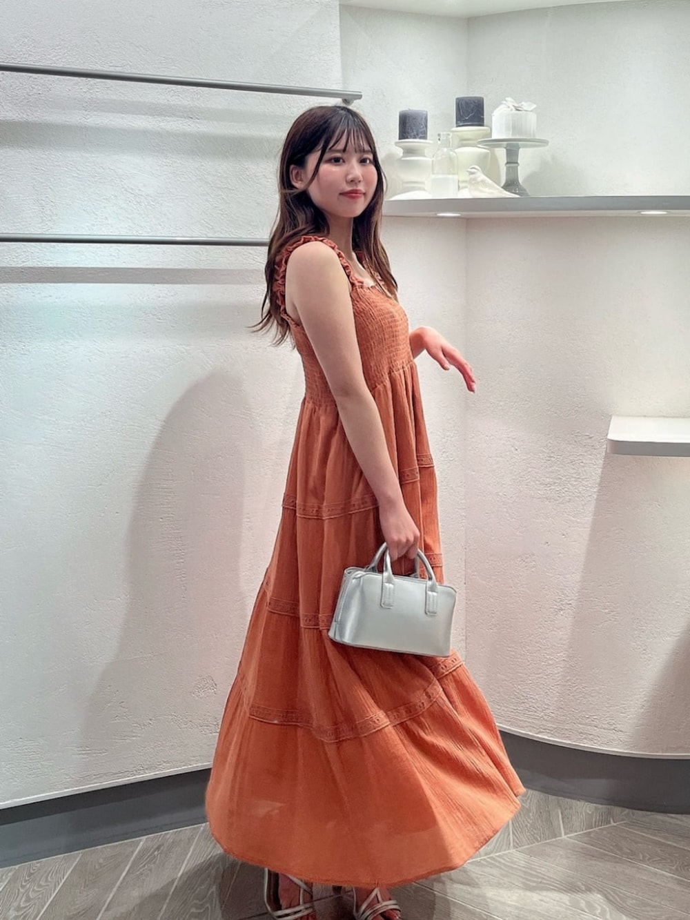 シルバー系のパンプス、ホワイト系のカーディガン/ボレロ、シルバー系のトートバッグを着用したレディースの夏コーディネートの2枚目の写真