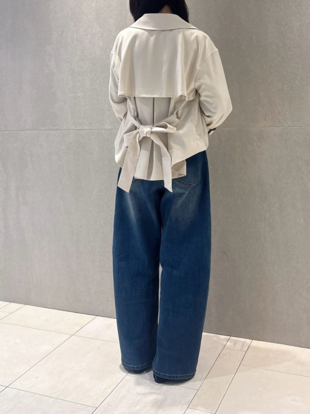 ホワイト系のトレンチコート、ブルー系のデニムパンツ、ブラック系のシャツ/ブラウスを着用したレディースの春コーディネートの3枚目の写真