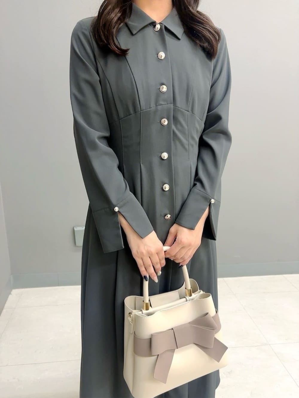 ブラック系のパンプス、ベージュ系のショルダーバッグ、グレー系のワンピースを着用したレディースの秋コーディネートの3枚目の写真