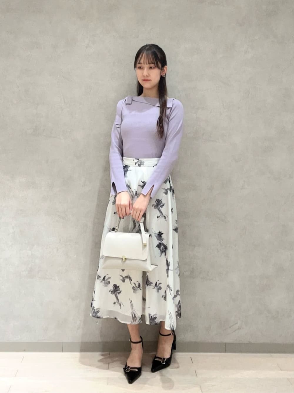 パープル系のニット/セーター、グレー系のスカート、ブラック系のパンプスを着用したレディースの冬コーディネートの2枚目の写真