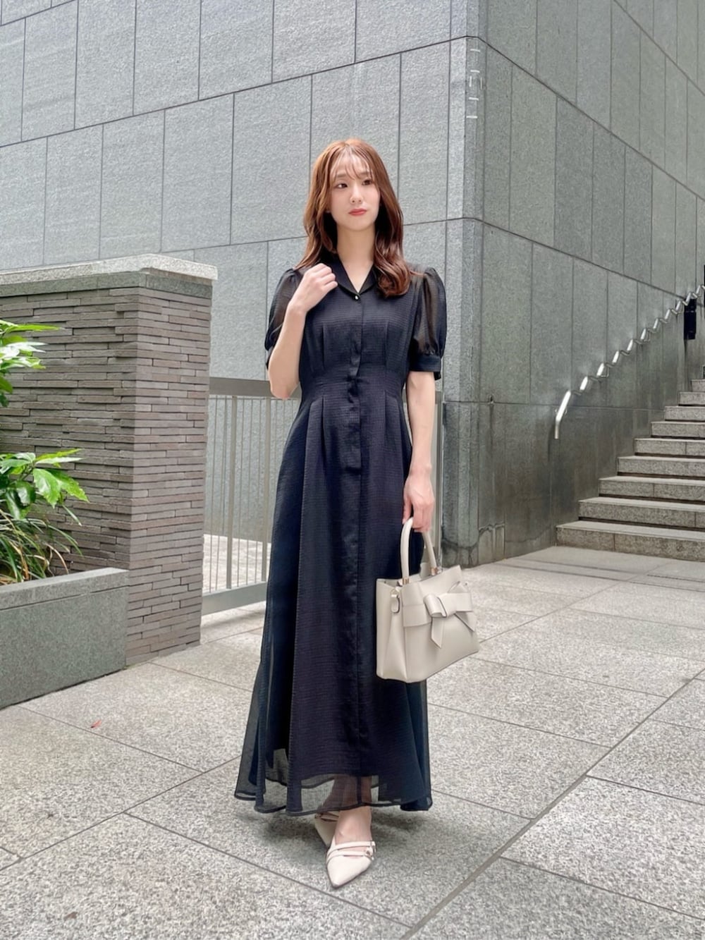 ホワイト系のショルダーバッグ、ブラック系のワンピースを着用したレディースの夏コーディネートの3枚目の写真