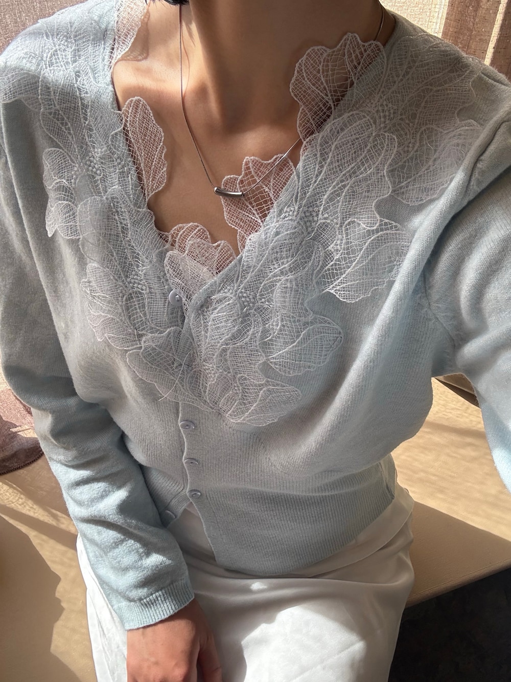 ブルー系のカーディガン/ボレロ、ホワイト系のスカート、イエロー系のパンプスを着用したレディースの春コーディネートの3枚目の写真