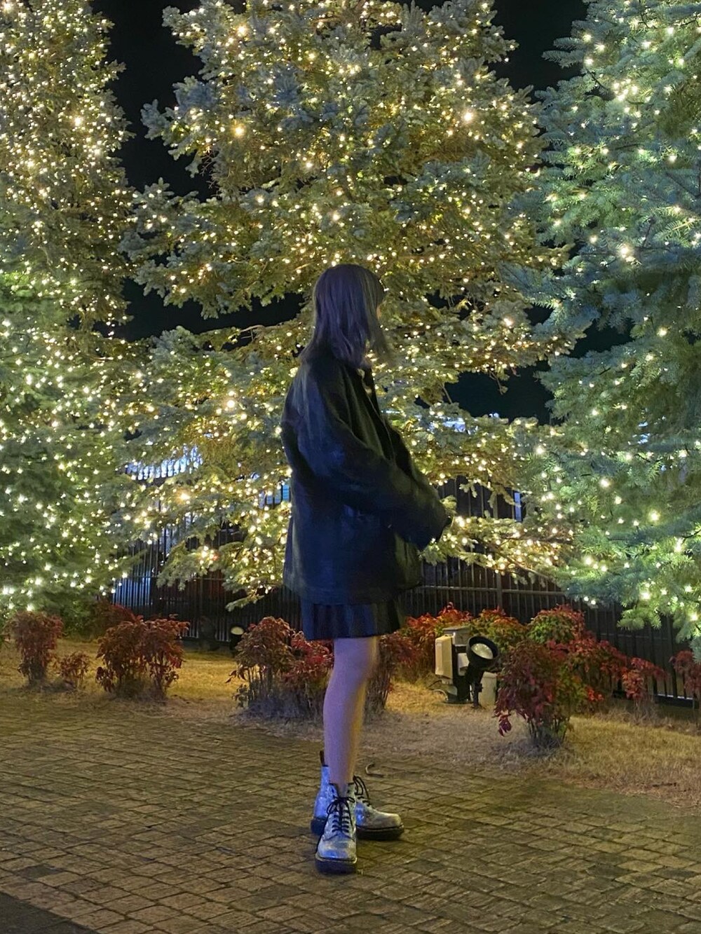 ブラック系のライダースジャケット、グレー系のスカート、ブルー系のブーツを着用したレディースの冬コーディネートの2枚目の写真