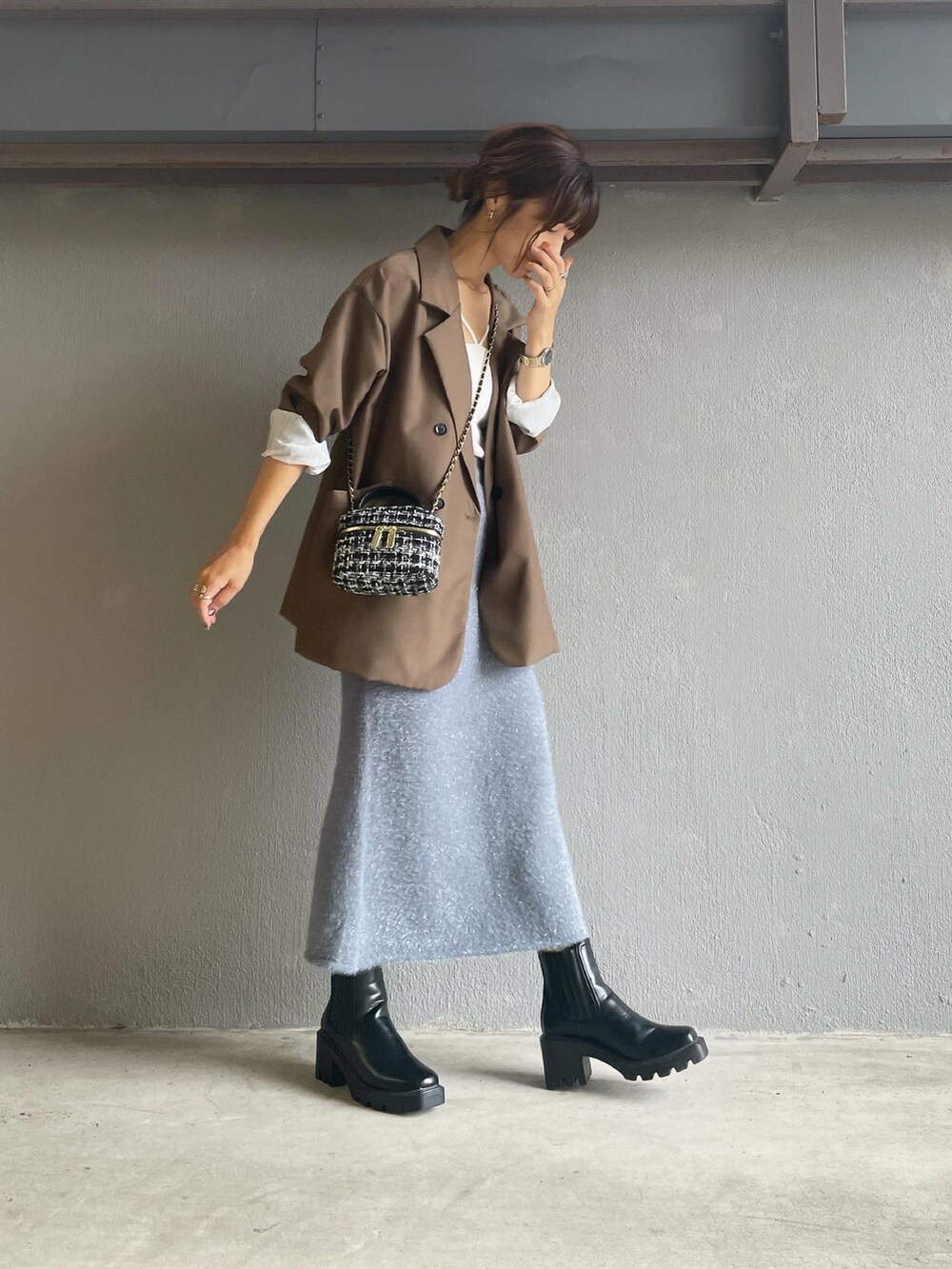 グレー系のスカート、ブラック系のブーツを着用したレディースの秋コーディネートの3枚目の写真