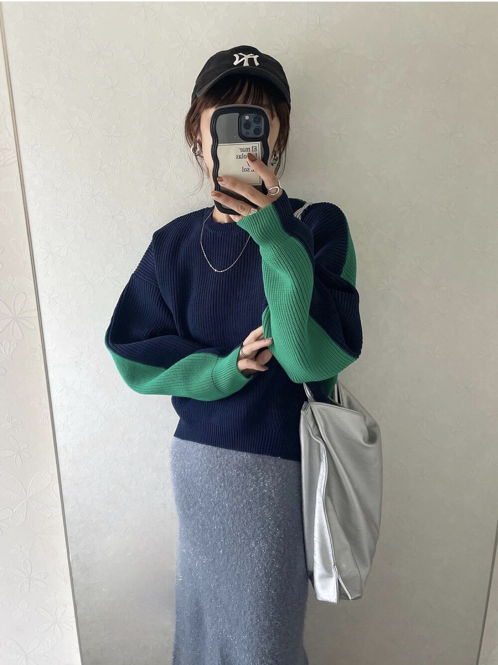 ブルー系のニット/セーター、グレー系のスカート、ブラック系のキャップを着用したレディースの秋コーディネートの2枚目の写真