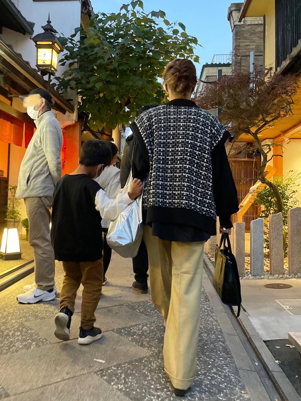 ブラック系のベスト、ゴールド系のブーツを着用したレディースの冬コーディネートの2枚目の写真