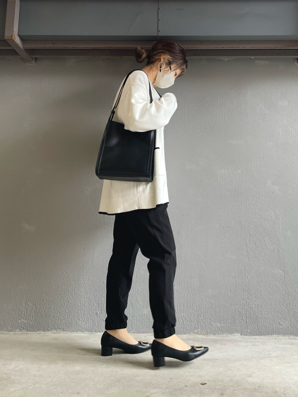 ブラック系のその他パンツ、ホワイト系のカーディガン/ボレロ、ブラック系のパンプスを着用したレディースの冬コーディネートの5枚目の写真