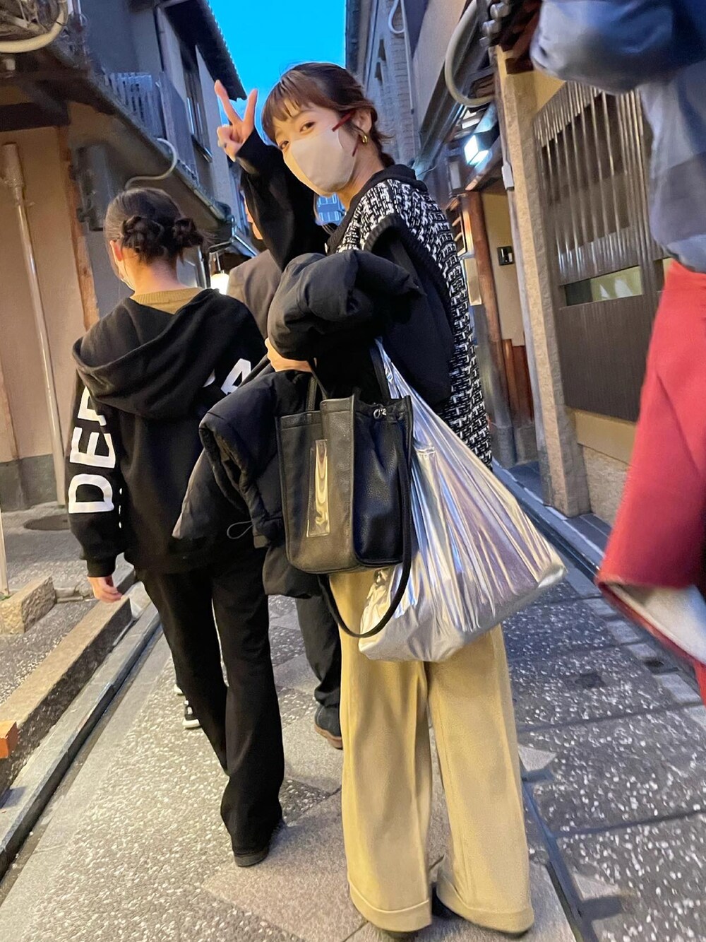 ブラック系のベスト、ゴールド系のブーツを着用したレディースの冬コーディネートの3枚目の写真