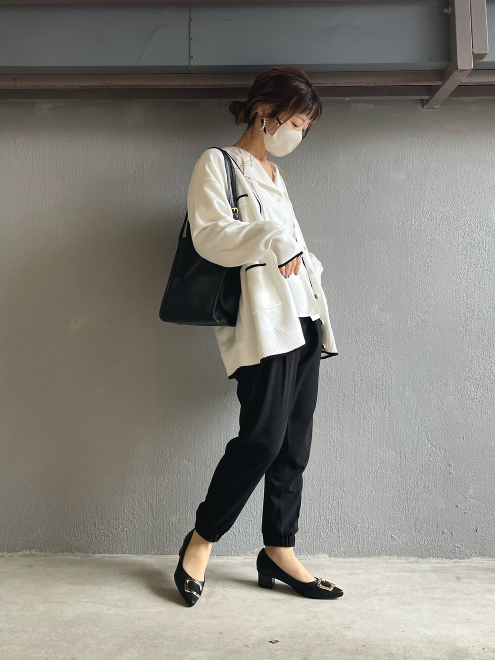 ブラック系のその他パンツ、ホワイト系のカーディガン/ボレロ、ブラック系のパンプスを着用したレディースの冬コーディネートの3枚目の写真