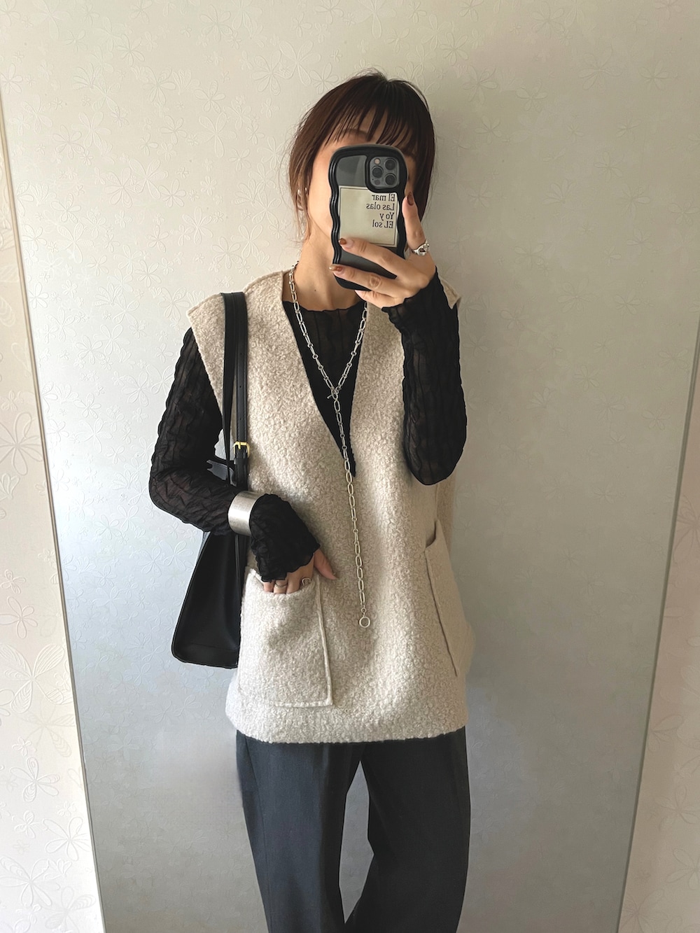 ベージュ系のベスト、シルバー系のネックレスを着用したレディースの秋コーディネートの2枚目の写真