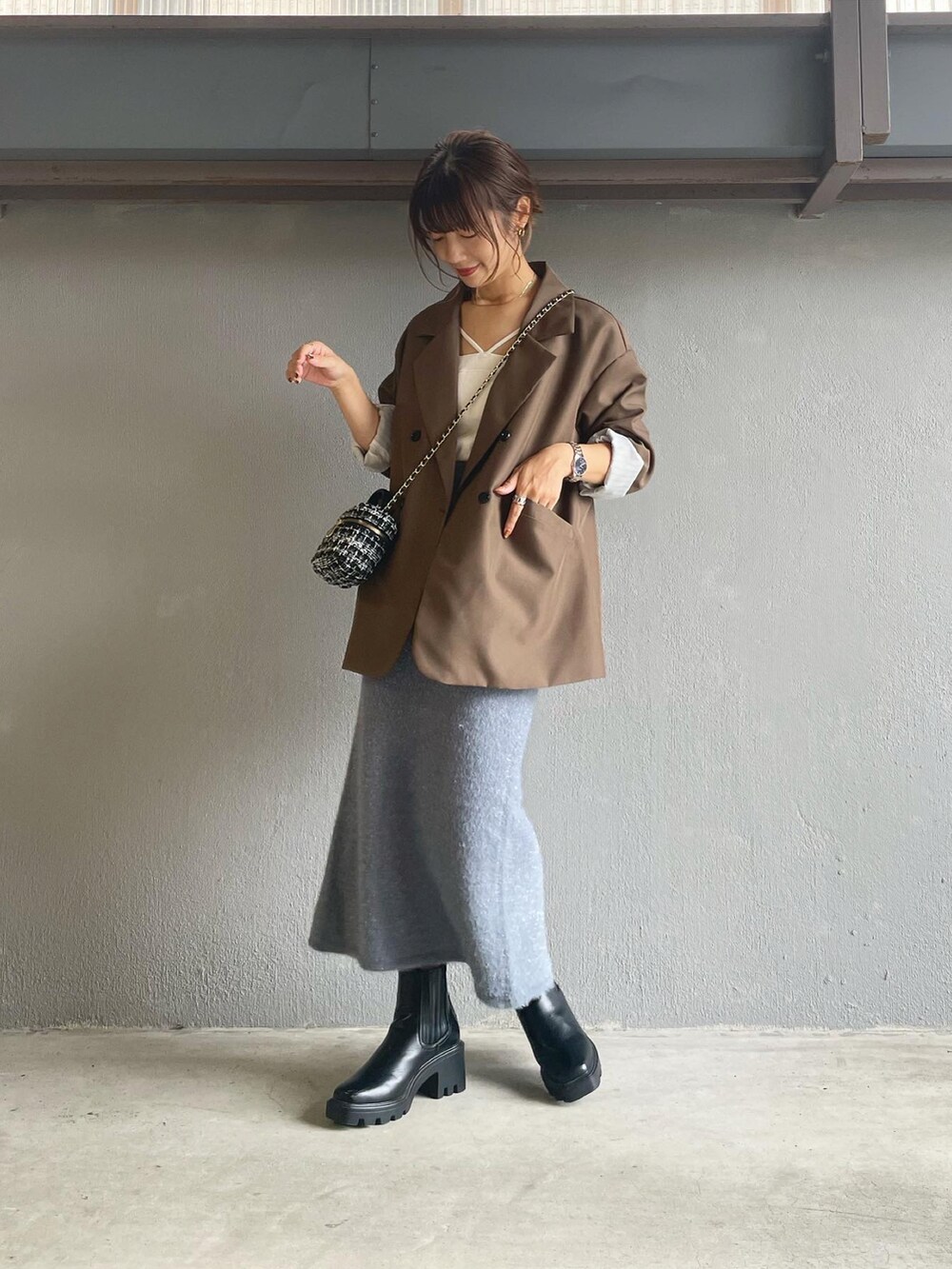 グレー系のスカート、ブラック系のブーツを着用したレディースの秋コーディネートの4枚目の写真
