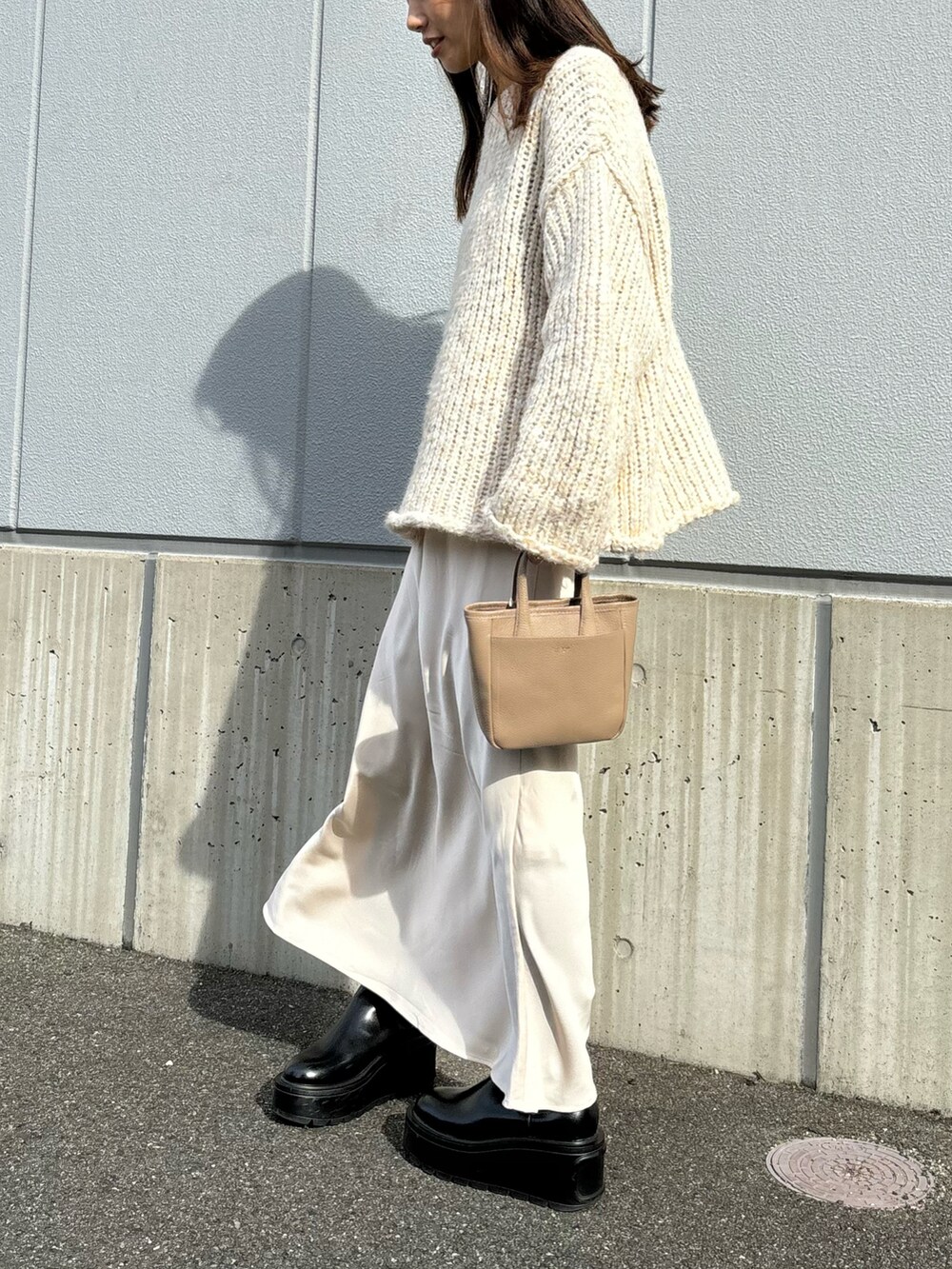 ベージュ系のニット/セーター、ベージュ系のスカートを着用したレディースの冬コーディネートの2枚目の写真